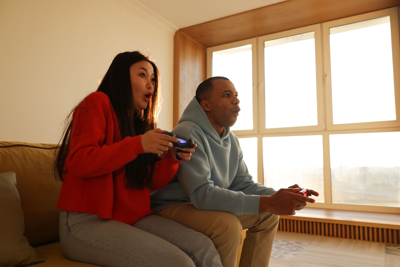 Un couple joue aux jeux vidéo sur un canapé