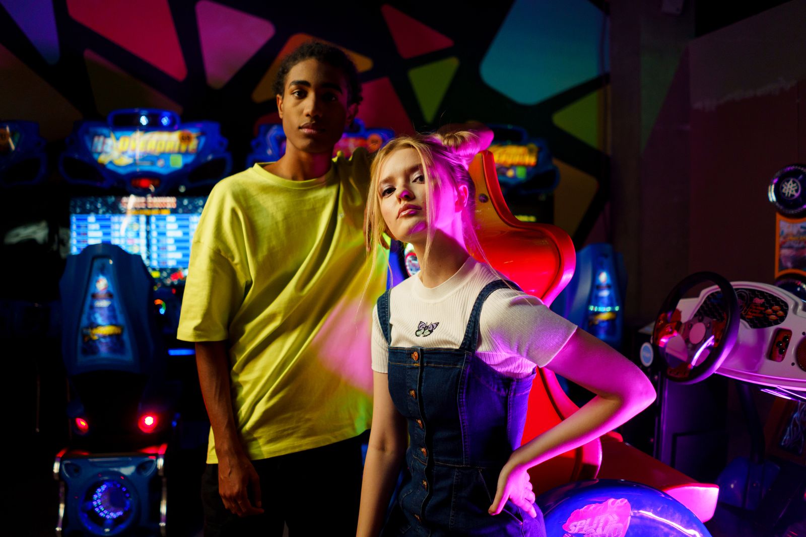 Two young people having fun in an arcade with colourful neon lights