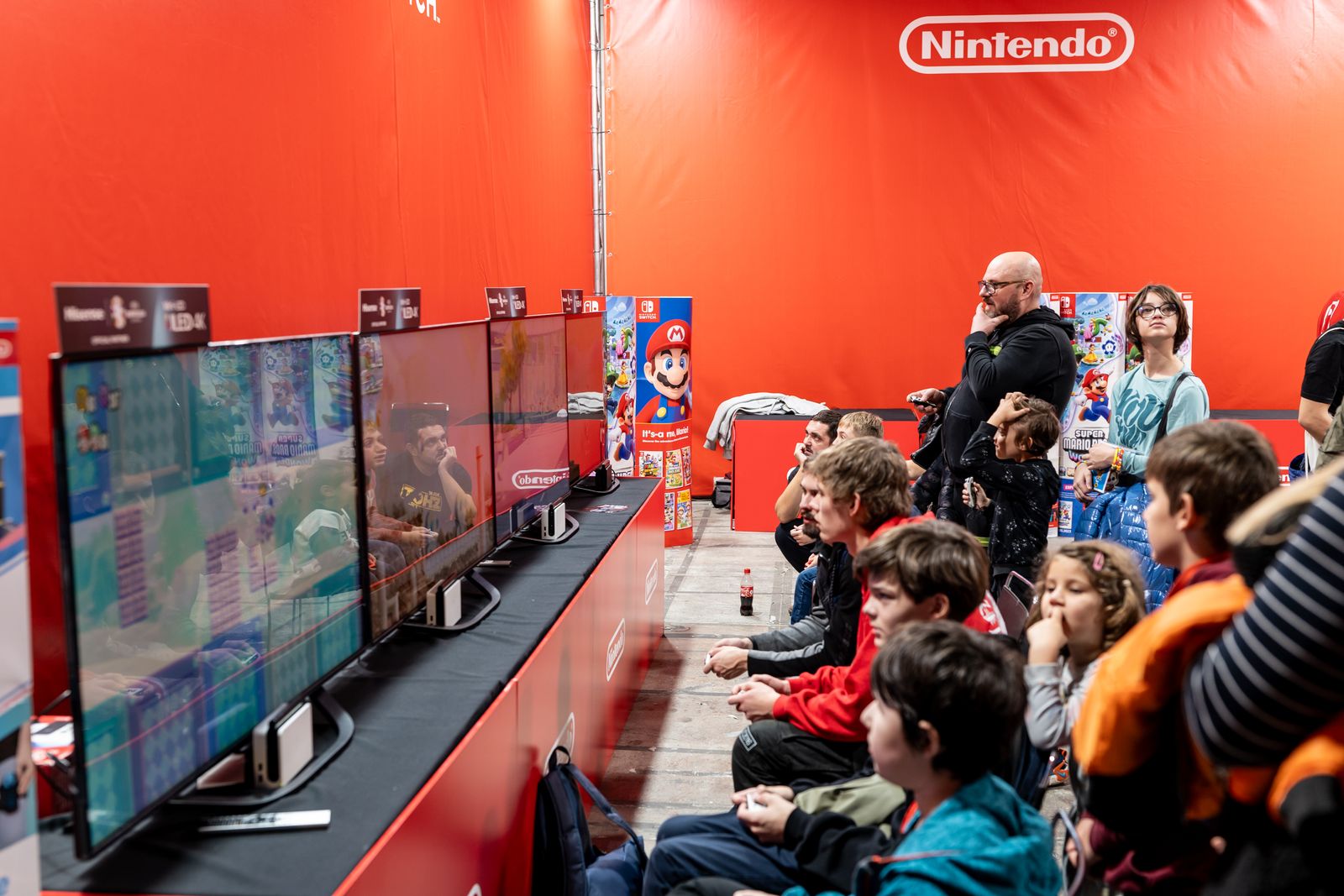 Des joueurs devant plusieurs écrans lors d’un événement de jeu vidéo
